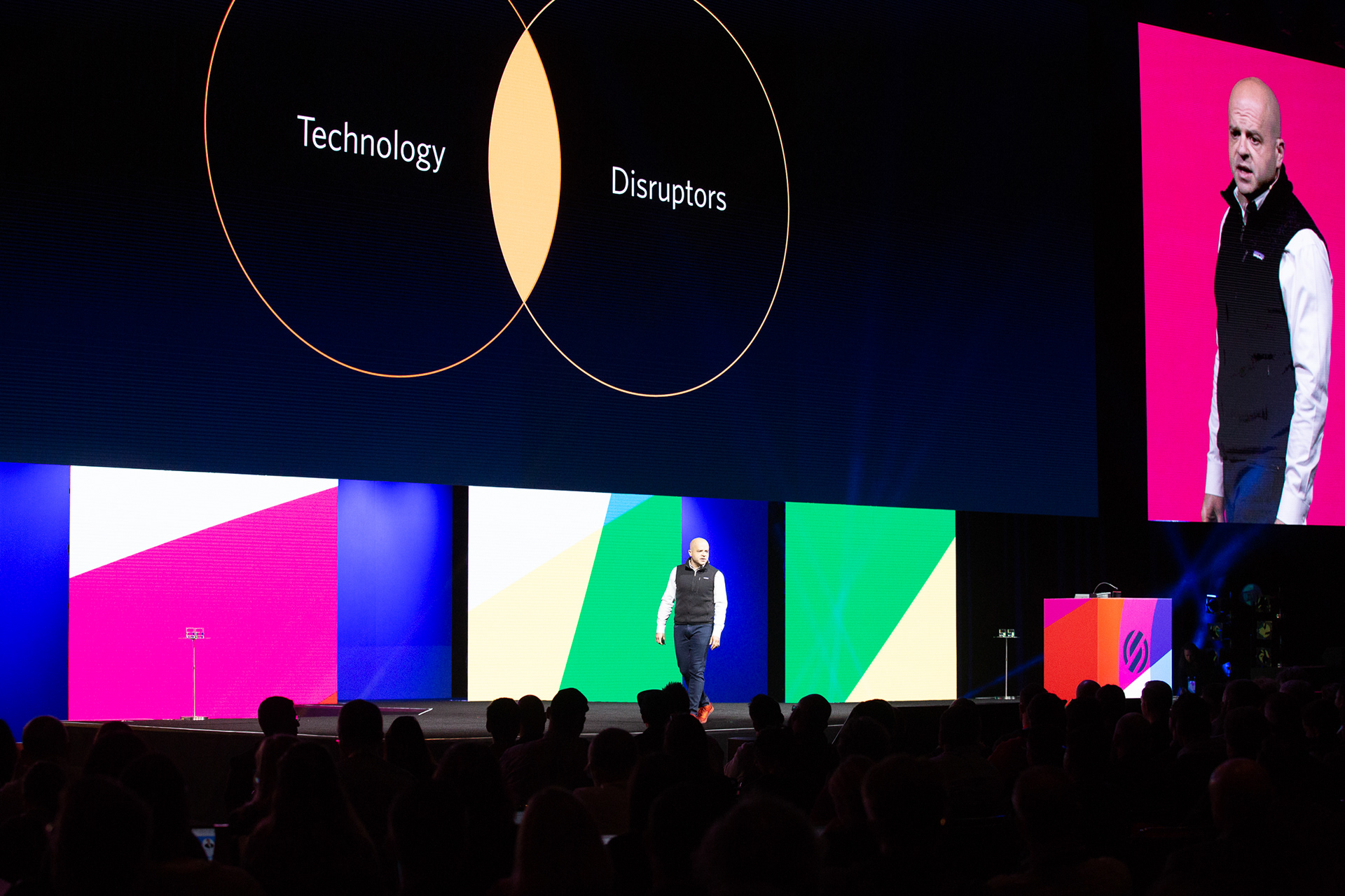 Speaker on Samsara stage with Technology and Disruptors Venn diagram on screen